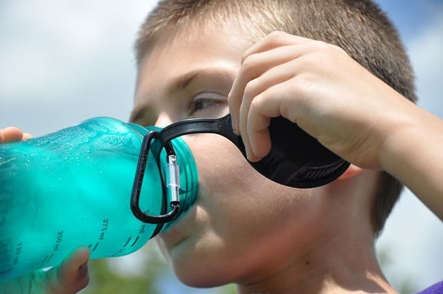 Young boy drinking from a water bottle
